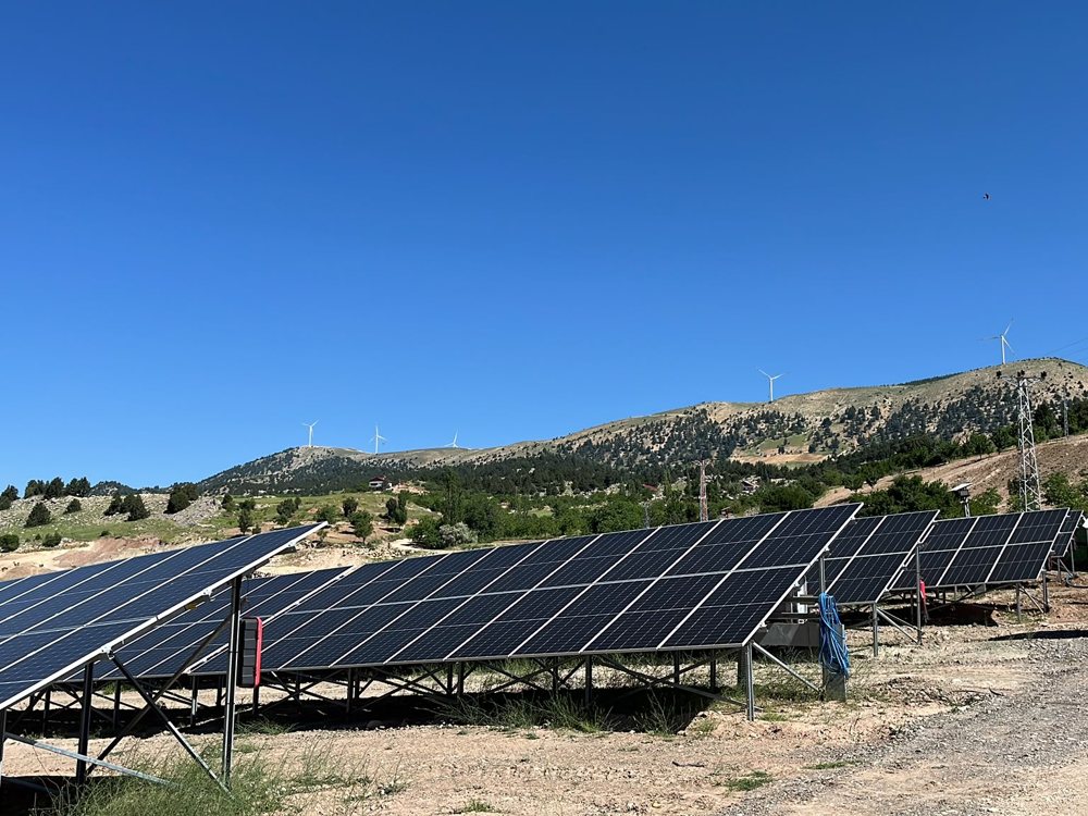 Arazi tipi GES kurulumu, rüzgar türbinleri manzaralı